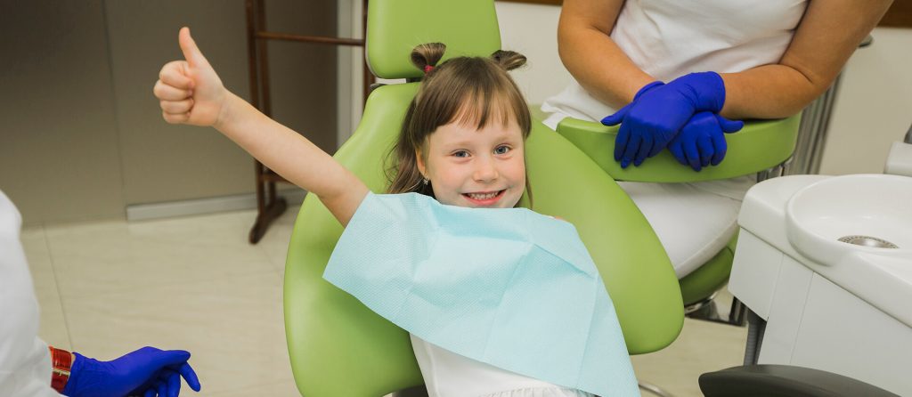 Dziewczynka na fotelu dentystycznym. Wizyta kontrolna u dentysty - Co zrobić, gdy dziecko się boi