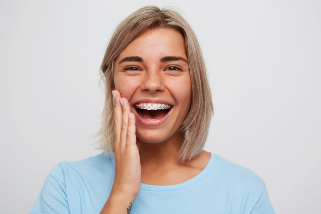 Uśmiechnięta kobieta. Rodzaje aparatów ortodontycznych i ich przeznaczenie
